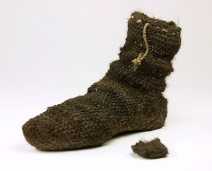 The Anasazi flourished in the 13th century. These ancestors of the Pueblo peoples left behind fascinating remnants of their rich material culture, including footwear. Regarded as exceptional artisans, they often used human hair, one of the most accessible and renewable fibres, to craft things such as nets and socks. This sock, which dates to the 13th century, was made by knotting strands of hair to form a sock and may have been worn alone or with a sandal.